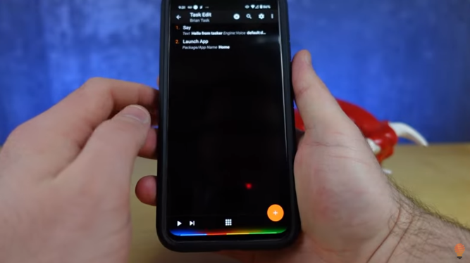 Picture of someone holding android phone with Tasker task on display