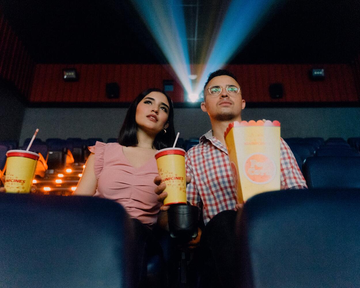 a couple watching movie with food in hands