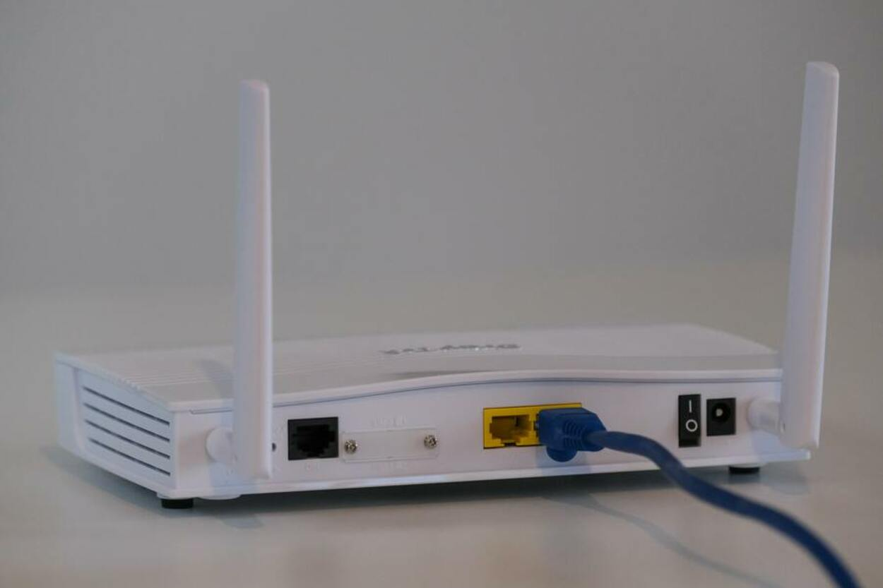 White Wi-Fi router with two antennas sitting on a white table