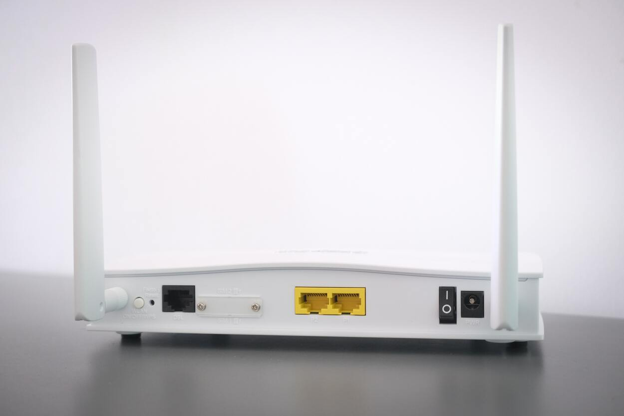 A picture of a router's back with different ports and power buttons.