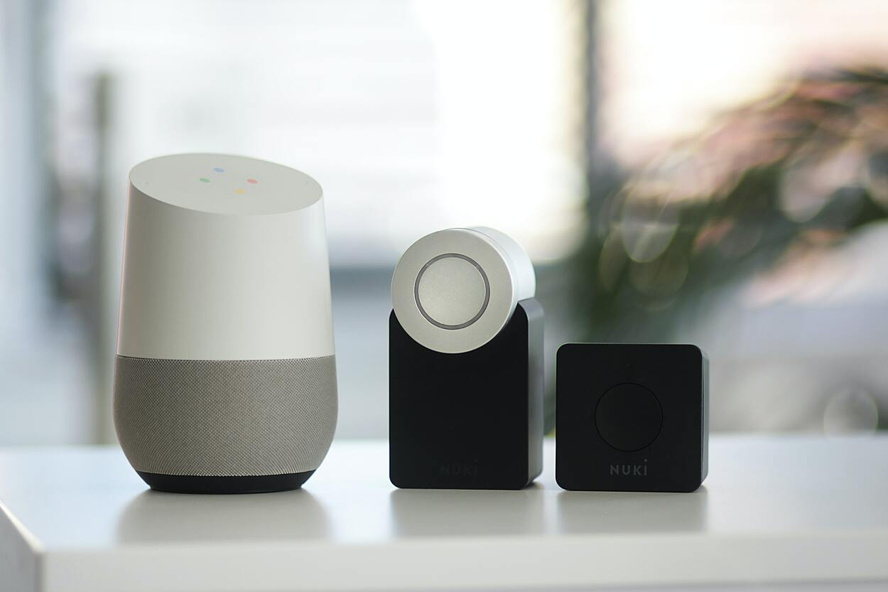 White and grey Google smart speaker and two NUKI speakers. 