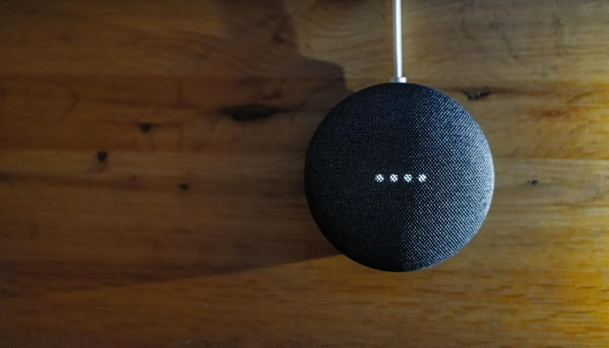 Google Nest Mini on top of a wooden table. 
