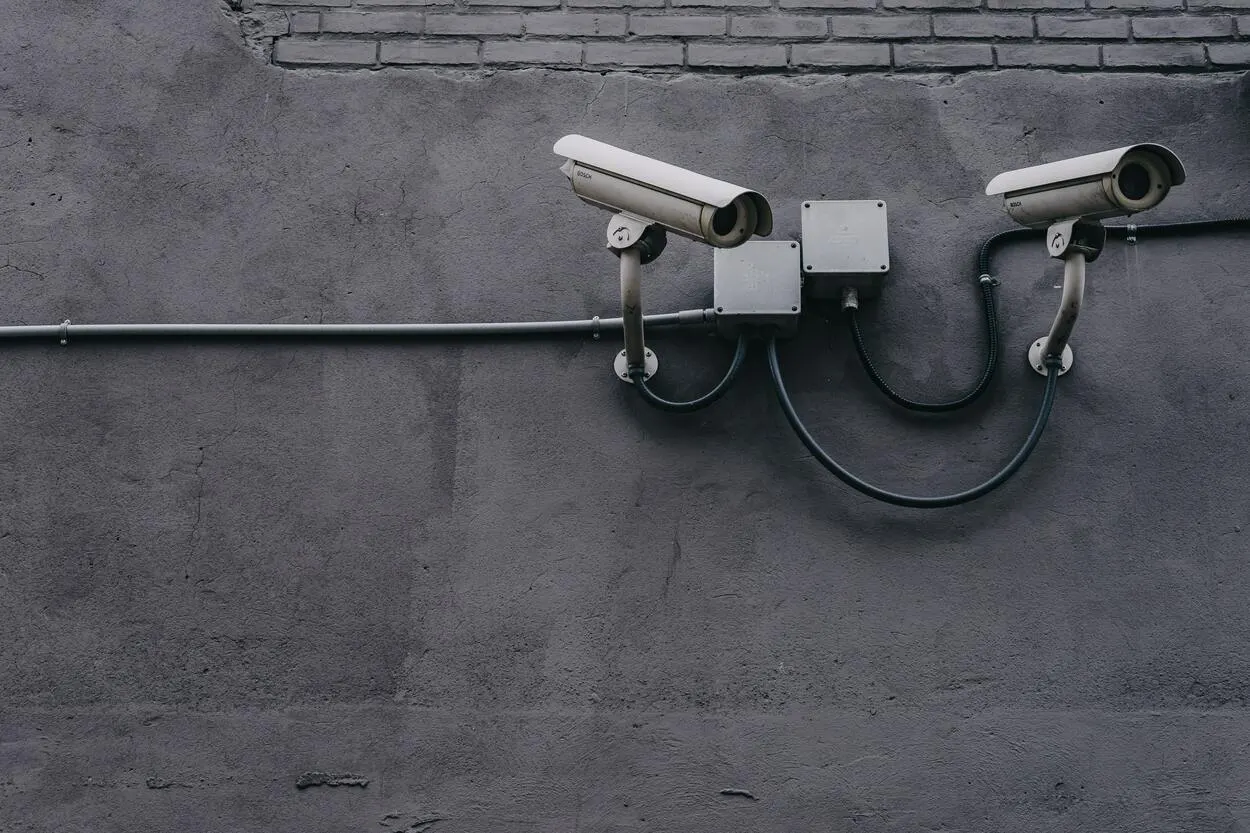 Two CCTV cameras mounted on a concrete wall