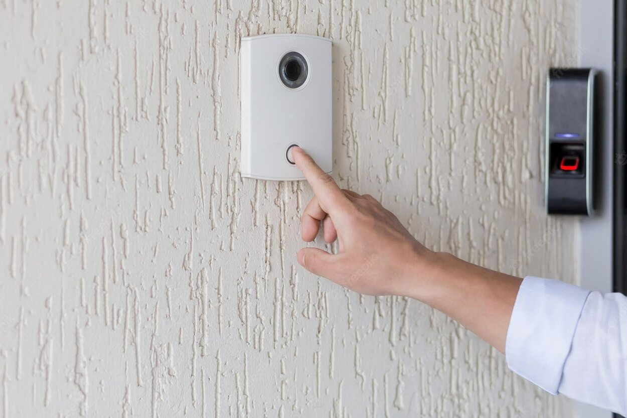 Image of a hand pressing button on ring doorbell.