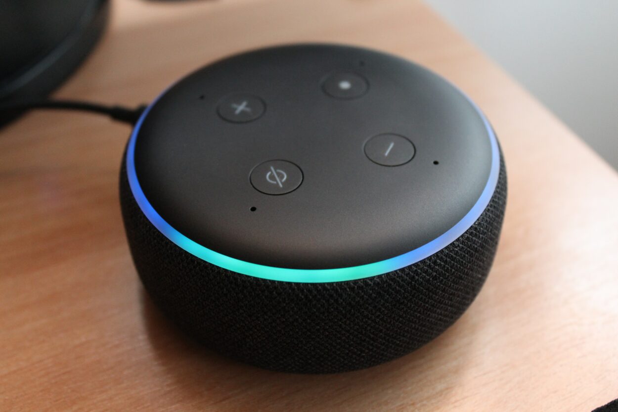 Alexa in black color placed on a brown surface