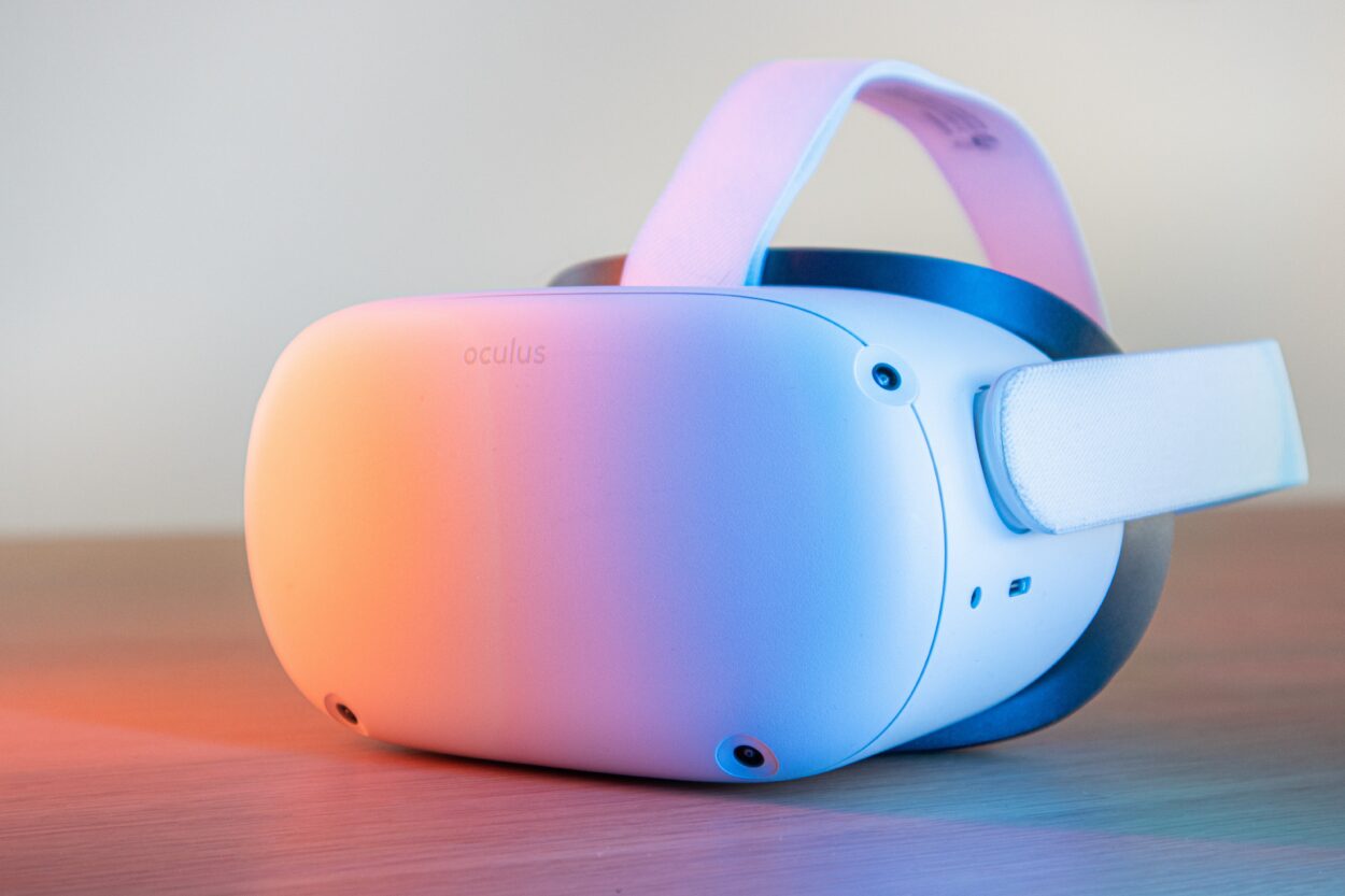 Oculus headset in white color placed on a surface with a pink colored light on it