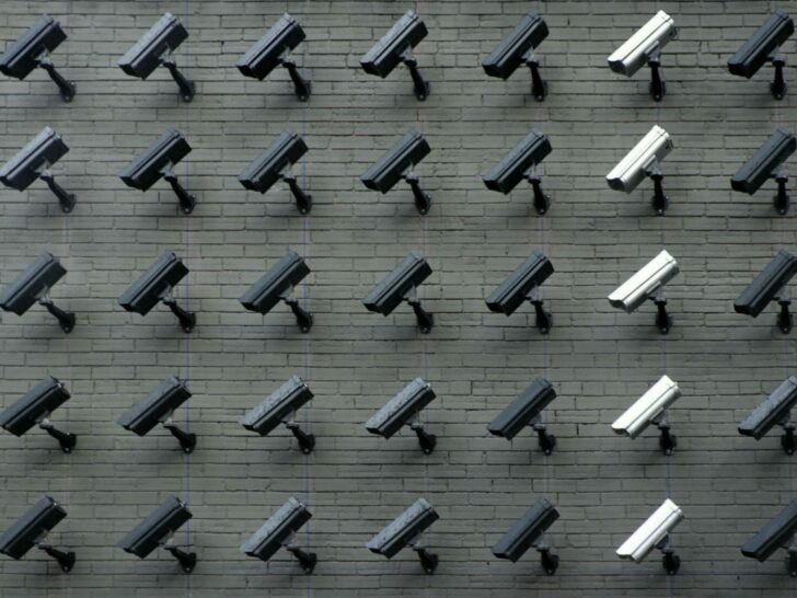 A bunch of cameras installed on a wall facing in the same direction