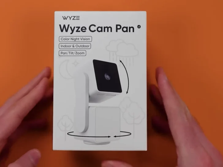 A person holding the box of Wyze Cam Pan V3