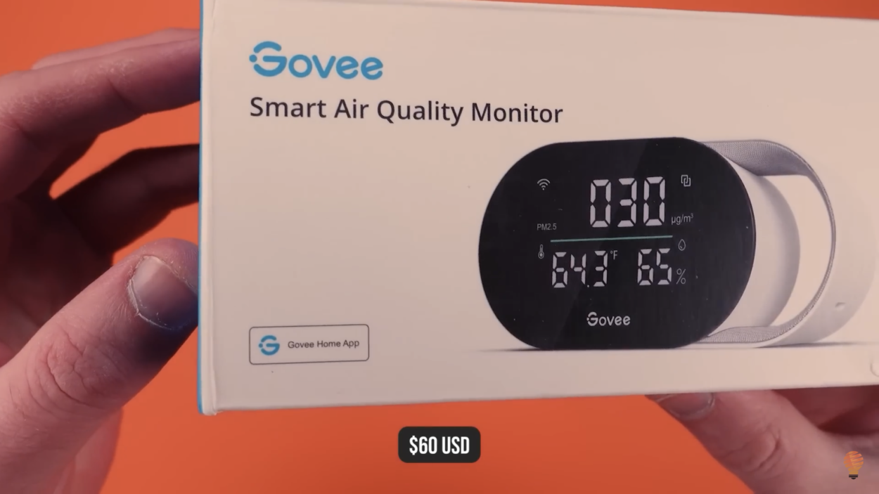 A person holding the box of Govee Air Quality sensor