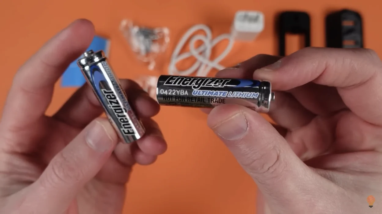 A person holding batteries for the Blink Video Doorbell