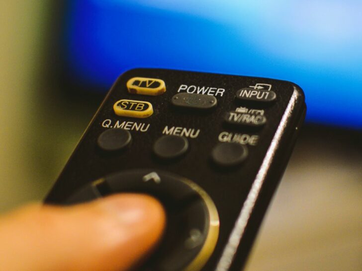 A person holding a remote to change the channel.
