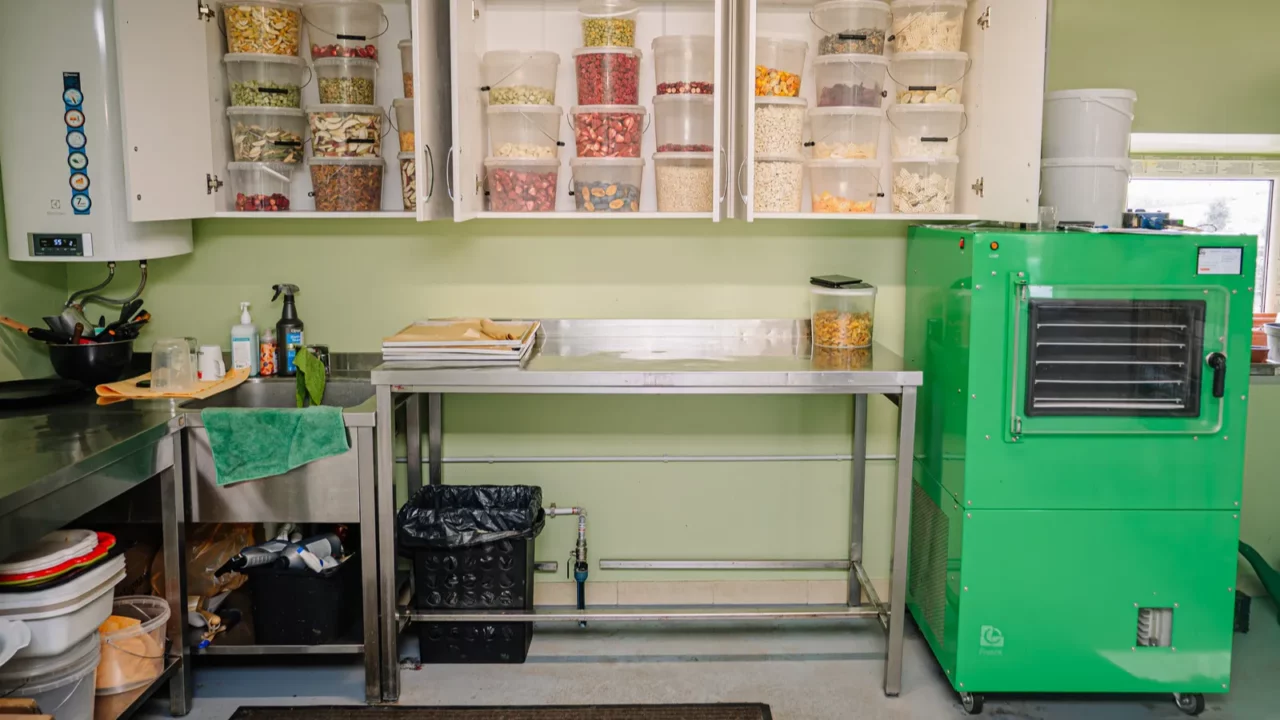Skillfully organized garage with freeze-dryer, cabinets and worktable.