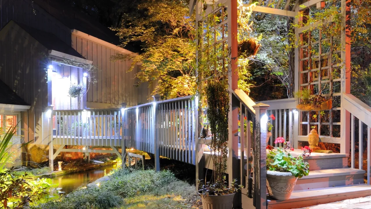 Patio with walkaway over a pond and elegant lighting.