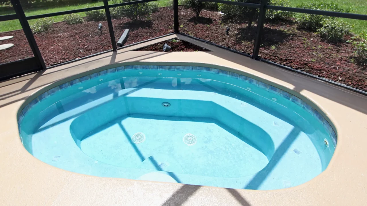 A jacuzzi in pool area of house.