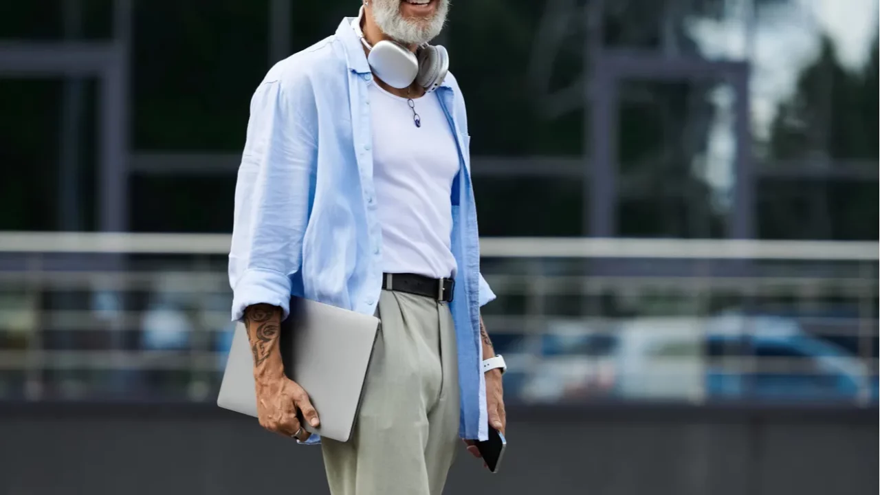 a mature gay man with a grey beard and tattoos
