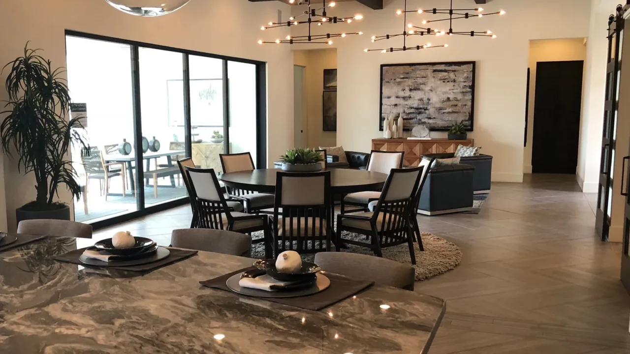 A newly furnished living room with dining table, big windows and fancy lights