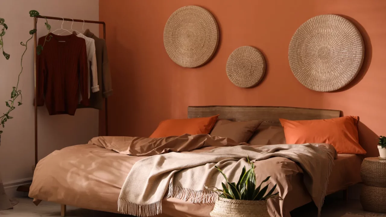 bed with orange and brown linens in stylish room interior