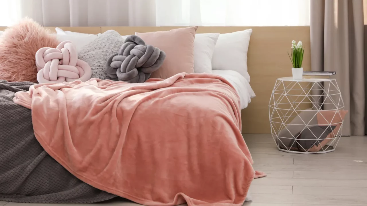 comfortable bed with pillows and plaid in modern room interior