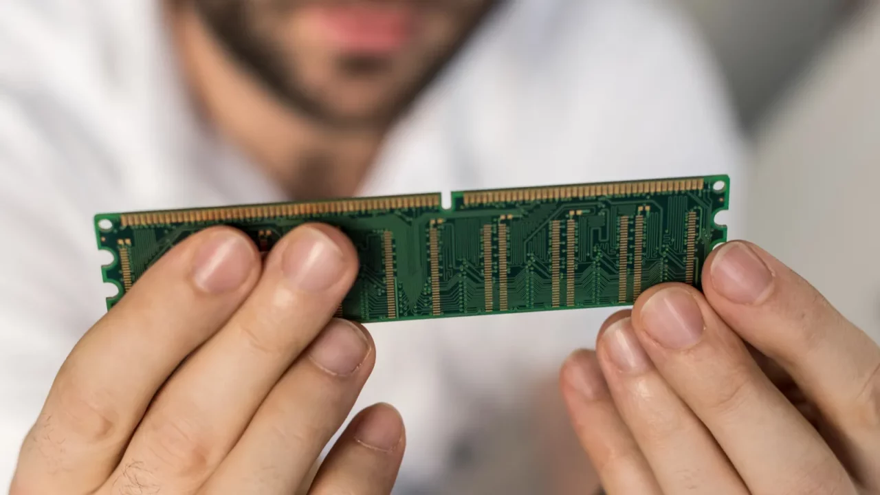 cropped image of man holding ram card in hands