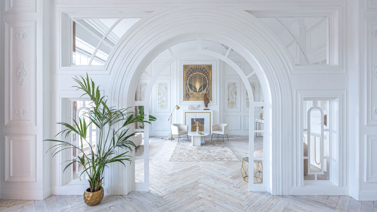 Snow-white luxury apartment interior with Egyptian-style decor with light stylish furniture. huge panoramic windows and an archway. minimalism and simplicity with the elegance of modern housing design