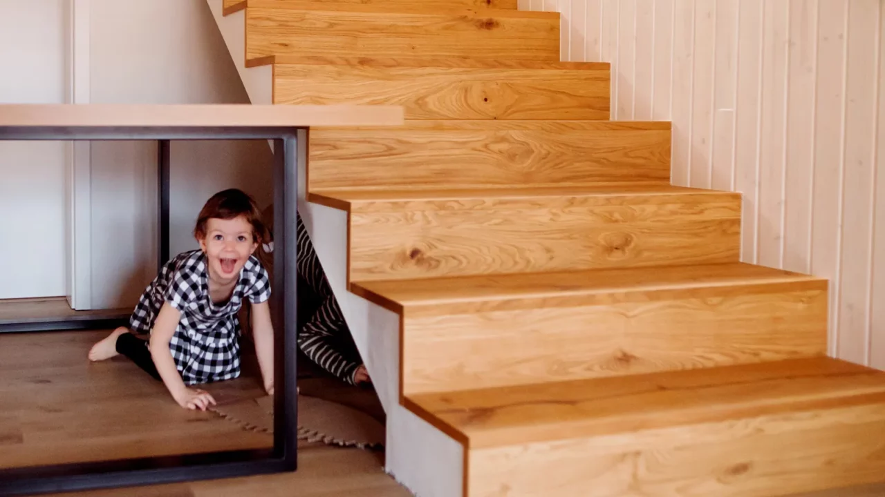 children playing at home hiding under stairs