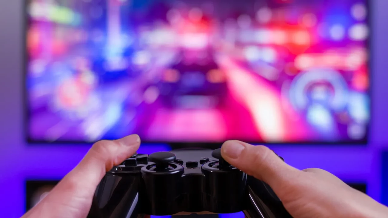 Joypad in hands gaming concept computer display with racing game.