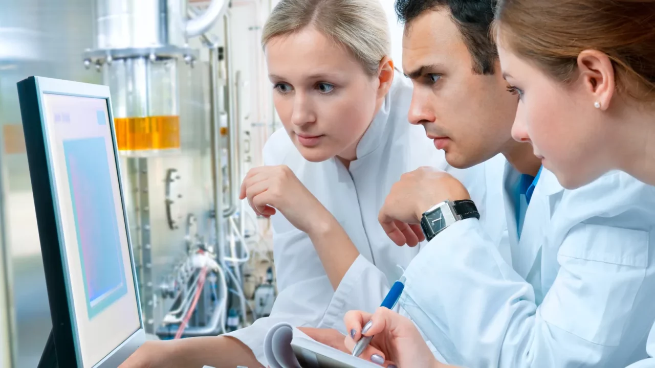 Three Scientists working on project in laboratory.