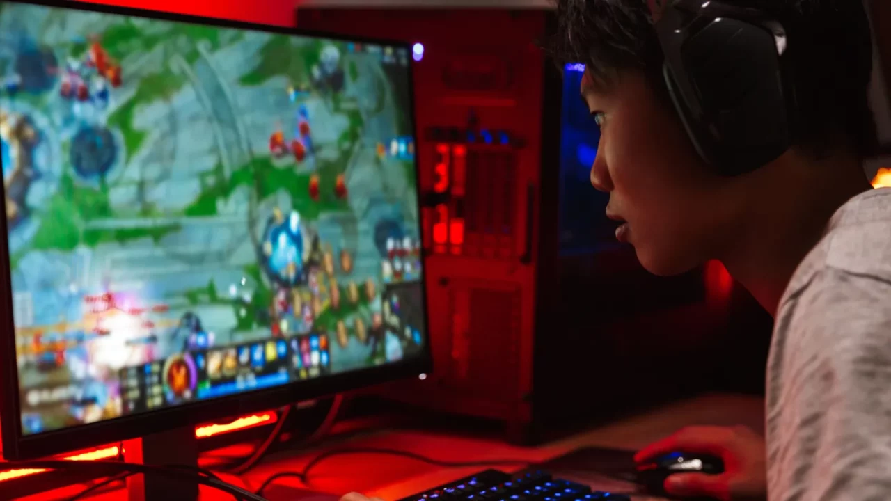 Portrait of asian gamer boy playing video games on computer.