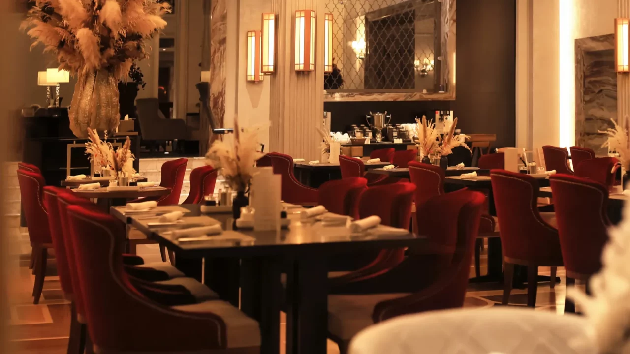 elegant hotel dining room with red velvet chairs dark tables