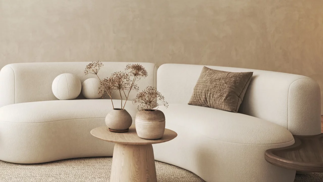 an elegant beige curved sofa with stylish decorative vases on