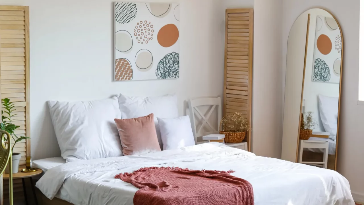 Cozy bedroom with white bedding and pink accents.